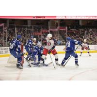 Cleveland Monsters' Joseph LaBate battles Syracuse Crunch's Steven Santini, Brandon Halverson, and Jaydon Dureau